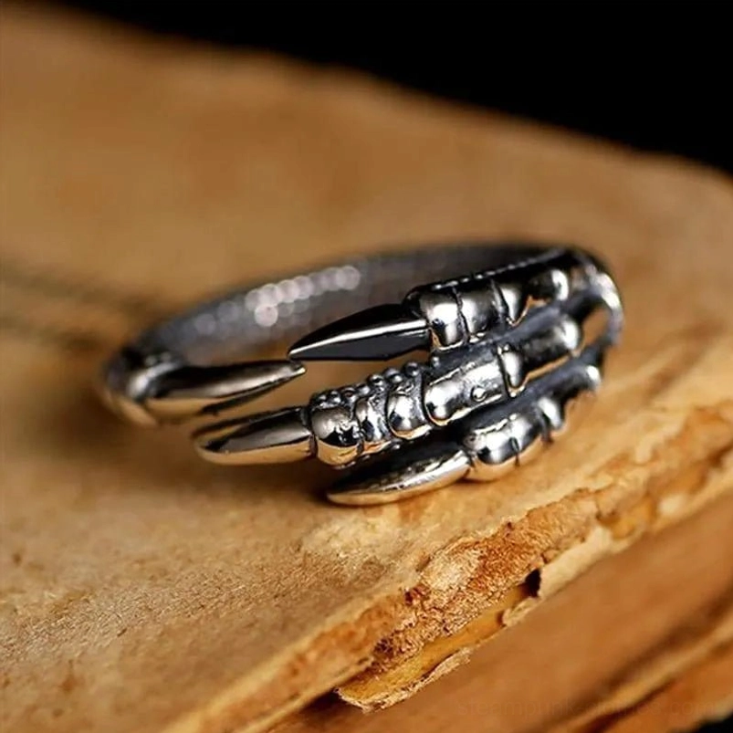 Sterling silver eagle claw steampunk ring side view with oxidized finish on vintage book background
