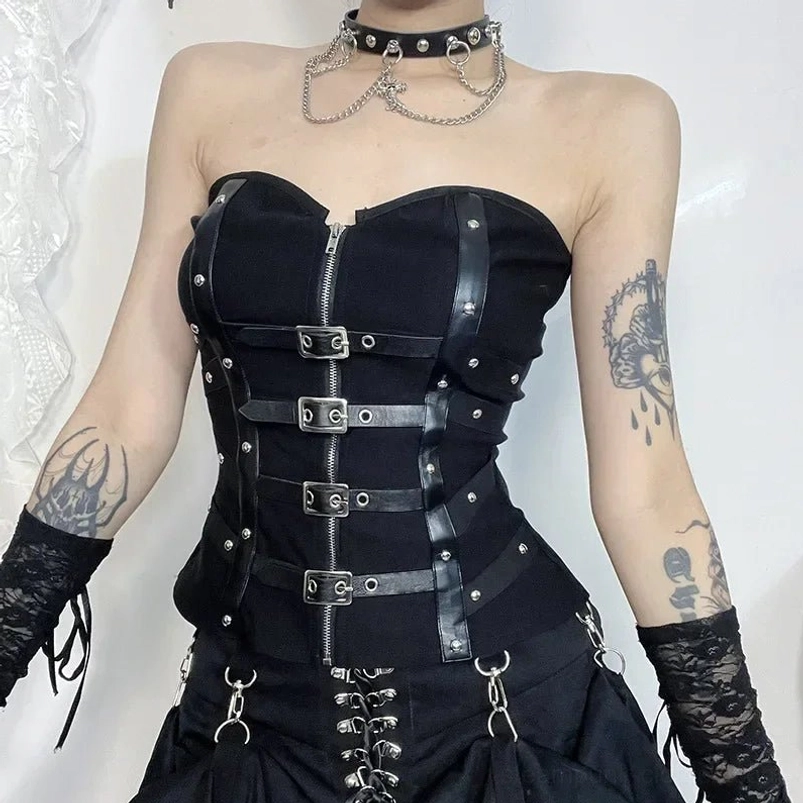 Strapless black steampunk corset front close-up with full-length metal zipper, leather buckle straps, and studded trim details on tattooed model against white lace backdrop