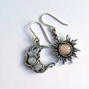 Asymmetric sun and moon steampunk earrings with antiqued silver wire wrap and natural gemstones on white background, flat lay view