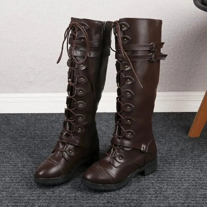 Pair of tall dark brown steampunk leather boots with dual buckle straps and premium construction detail on carpeted floor