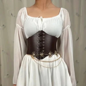 Brown leather underbust corset waist cincher featuring intricate double-layered gold chain sun decorations paired with elegant white square-neck dress, front torso display highlighting lace-up construction