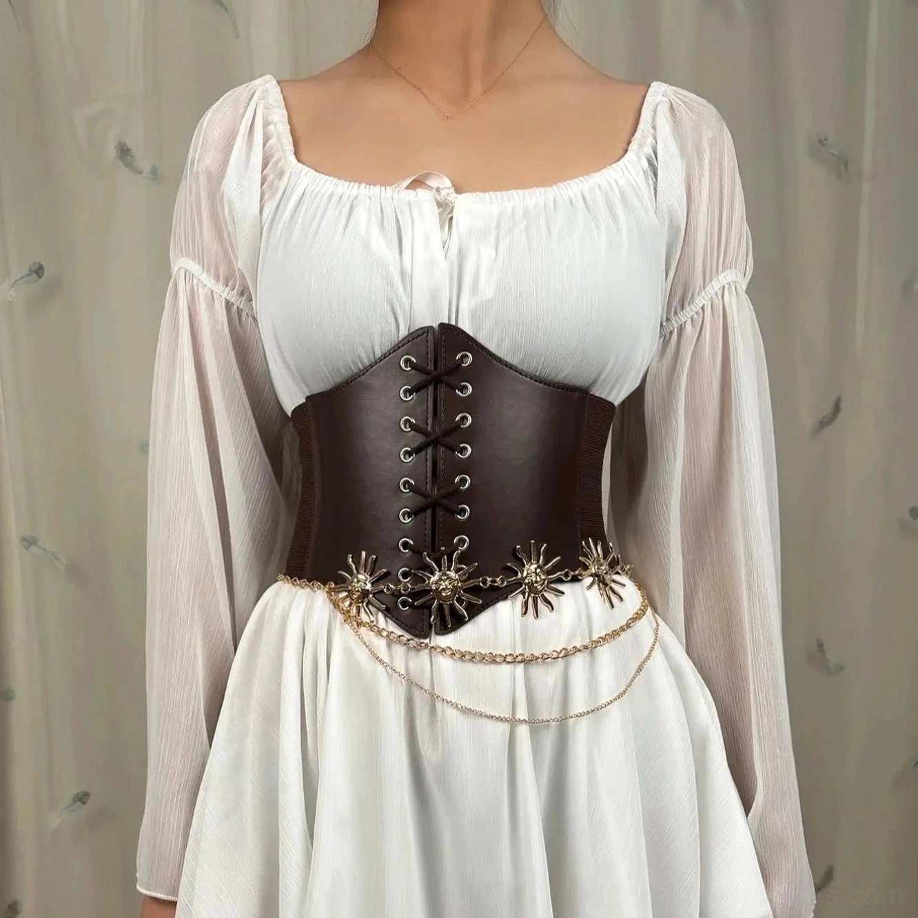 Brown leather underbust corset waist cincher featuring intricate double-layered gold chain sun decorations paired with elegant white square-neck dress, front torso display highlighting lace-up construction