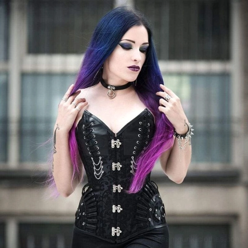 Venomous black steampunk gothic corset with damask jacquard fabric worn by model with ombre hair, featuring silver hardware and lace-up design on urban street backdrop