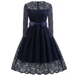 Veronica navy blue steampunk dress with sheer lace sleeves and bow waist detail, front view on white background