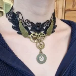 Black lace steampunk choker necklace with bronze gear and wing charms worn close-up on model neck - intricate Victorian floral lace detail front view