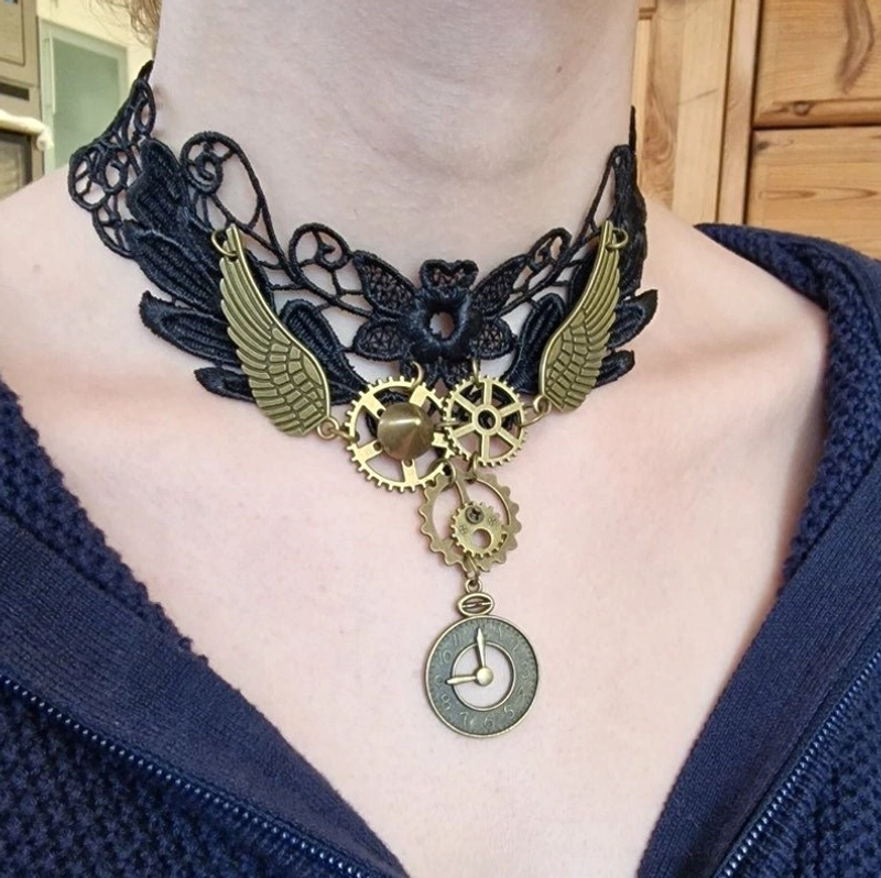 Black lace steampunk choker necklace with bronze gear and wing charms worn close-up on model neck - intricate Victorian floral lace detail front view