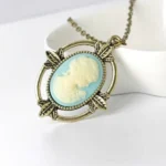 Victorian cameo profile necklace with antique bronze leaf frame on ceramic tray, steampunk jewelry style