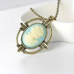 Victorian cameo profile necklace with antique bronze leaf frame on ceramic tray, steampunk jewelry style