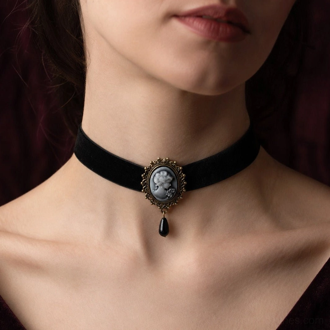 Victorian cameo velvet choker necklace worn on model's neck, showcasing black velvet band with ornate bronze filigree frame and grey cameo pendant against dark vintage backdrop