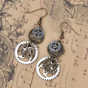 Two-tone steampunk gear earrings with bronze ear hooks displayed on vintage sheet music and floral pattern background, dangling earrings design from oblique angle