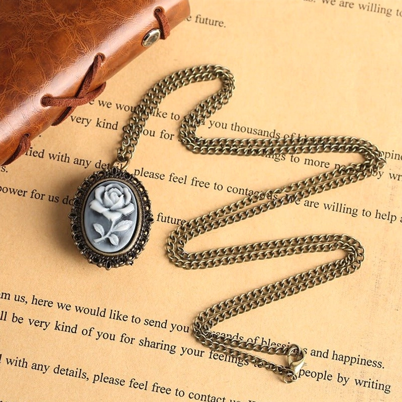 Victorian rose cameo pocket watch necklace displayed on vintage stationery background, showing bronze metal casing and resin rose cameo design - steampunk aesthetic jewelry