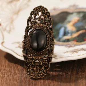 Bohemian steampunk adjustable ring with ornate bronze scrollwork and dark central stone, frontal perspective