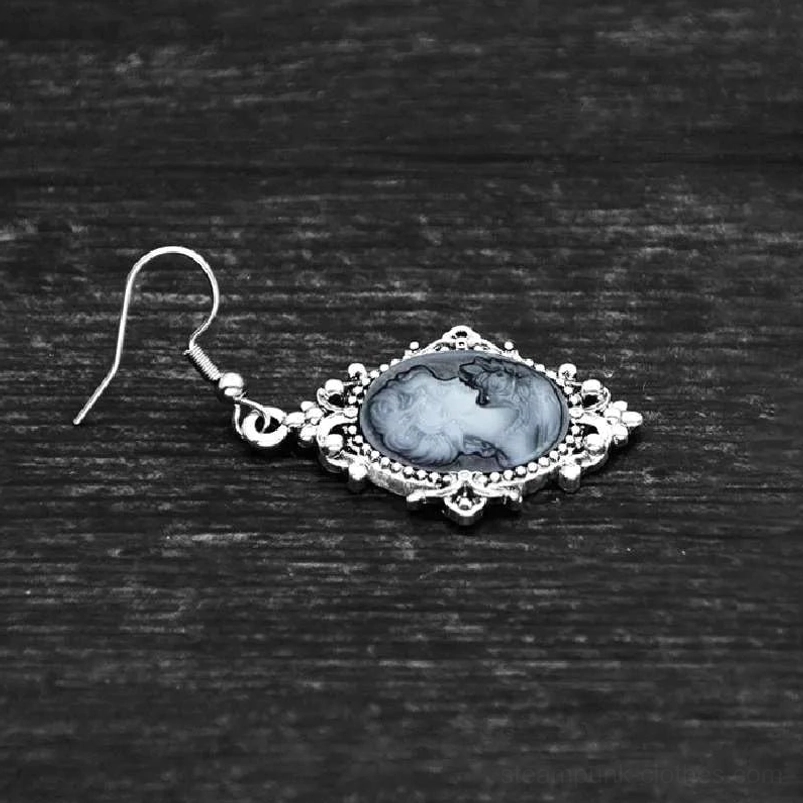 Single Victorian cameo drop earring side view showcasing delicate silver filigree work and marbled grey-white female portrait against wooden background