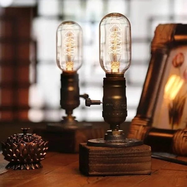 Vintage desk lamp with Edison filament bulbs and industrial steampunk aesthetic, showcasing aged bronze metal components and solid wood base