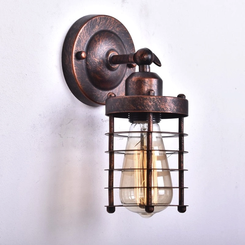 Vintage cage wall light right front angle showing weathered brown metal frame, downward-facing lamp cage, and exposed filament bulb