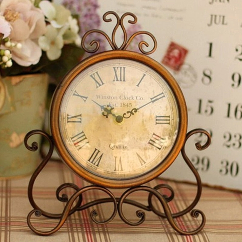Vintage iron desk clock with ornate scroll top and warm bronze finish, displaying intricate metalwork details