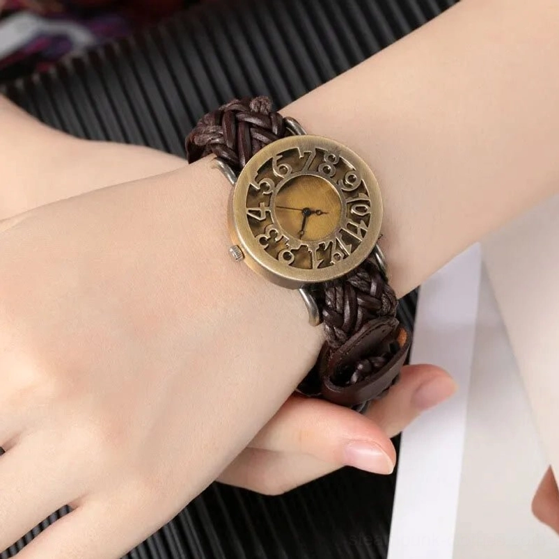 Steampunk wristwatch on model hand, close-up perspective showing dark brown braided leather strap and bronze vintage numerals against striped tabletop