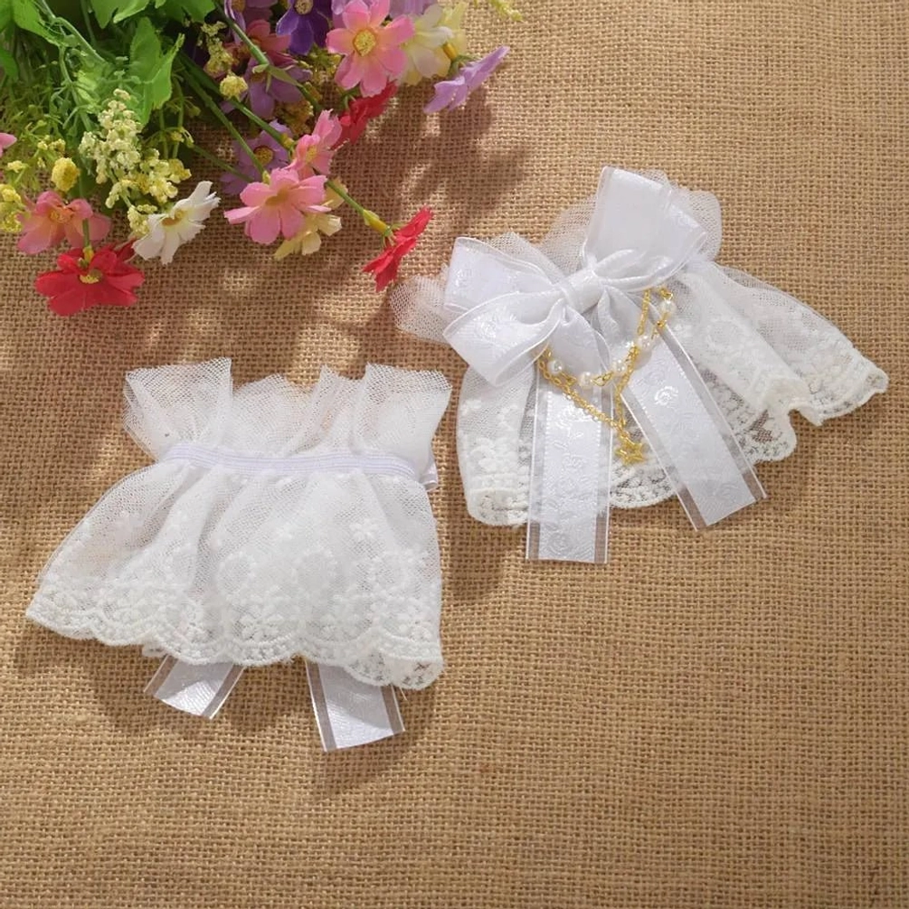 Basic white lace steampunk wrist cuffs with ribbon fasteners and decorative lace trim, top view on burlap background with floral styling props