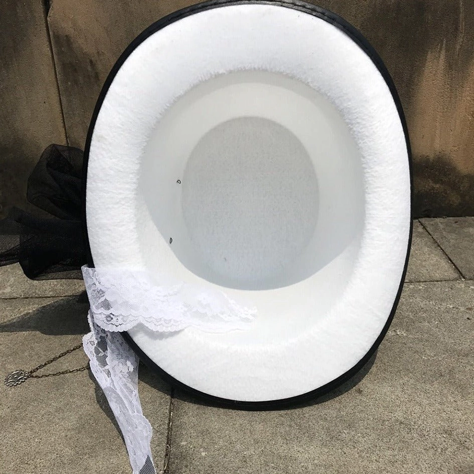 Interior overhead view of white steampunk top hat showing soft fuzzy white fabric lining and black brim edge reinforcement on concrete background