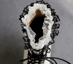 Close-up interior top-down view of white Victorian steampunk boot showing dual-layer lace ruffles, soft fleece lining, and front lace-up design