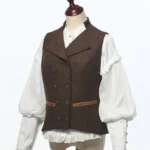 Women's dark brown tweed steampunk double-breasted vest worn with vintage ruffled puff-sleeve blouse, showing front three-quarter view and tailored silhouette with adjustable back straps