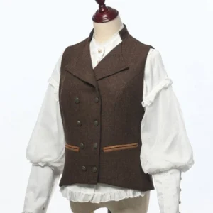Women's dark brown tweed steampunk double-breasted vest worn with vintage ruffled puff-sleeve blouse, showing front three-quarter view and tailored silhouette with adjustable back straps