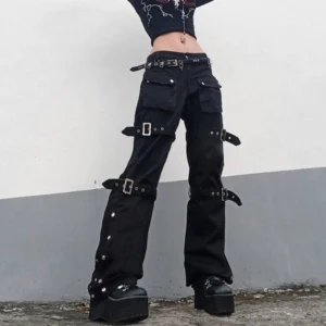 Women's black steampunk cargo pants with silver buckles worn by model in outdoor setting, featuring low-rise design and side snap fasteners