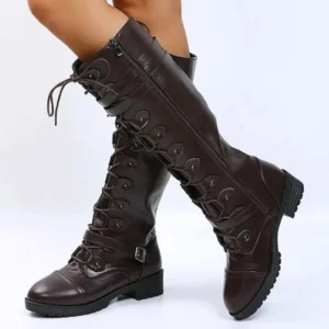 Women's steampunk combat boots side view showing ankle buckle strap, block heel design, and lace-up construction with studio background