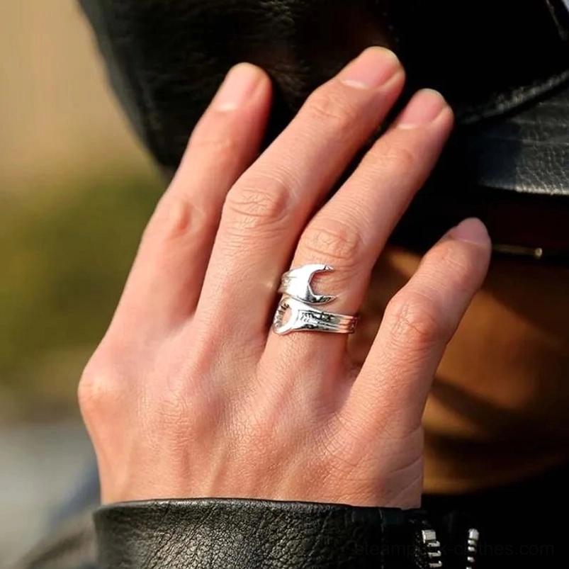 Wrench steampunk ring on male hand with leather jacket background showcasing crescent wrench shape and engraved band details in outdoor setting